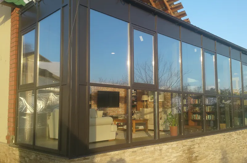 Взгляд изнутри помещения на улицу через алюминиевый витраж TFS50. Минималистичные рамы не загромождают обзор, создавая единство с окружающим пространством. Система совместима с теплыми стеклопакетами.